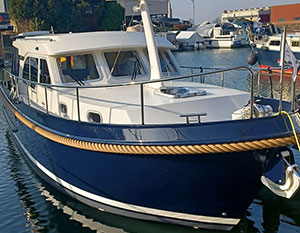 Linssen 30.0 Sedan Amy im Hafen, Steuerbordseite, vom Bug Richtung Heck sehend, von Land aus, mit geschlossenem Dach