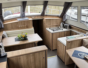 Avalon Salon, Blick nach Steuerbord vorne, rechts die Pantry mit Spüle und Kochplöatte. Loinks Tisch und 2 Sitzbänke.