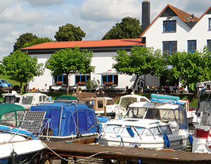 Mirow Hafen. Blick vom Anleger aus über Boote zum Restaurant