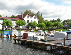 Der Hafen in Morow mit Anleger im Vordergrund und Restaurant am Ufer 